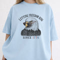 WZ_eagle_letting_freedom_ring_shopify_comfort_colors_1717_mockup_woman_2_chambray